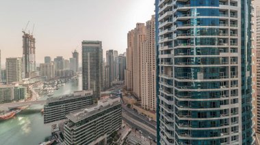 Panorama showing overview to JBR and Dubai Marina skyline with modern high rise skyscrapers waterfront living apartments aerial. Yachts floating on water of canal. JLT district on a background