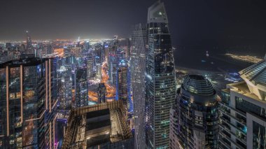 Panorama JBR bölgesini ve Dubai Marina 'yı JLT ile gösteriyor. Gökdelenler arasındaki otoyolda trafik vardı. Hava gece zaman çizelgesi. Aydınlatılmış modern kuleler ve inşaat alanı