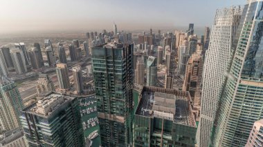 Panorama sabah Dubai Marina ve JLT 'yi JBR bölgesinde gösteriyor. Gökdelenler arasındaki otoyolda hava trafiği. Modern kuleler ve inşaat alanı. Limanda yüzen yatlar