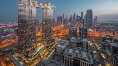 Fütürist Dubai Şehir Merkezi ve finans bölgesi gökyüzü gece gündüz geçiş zamanı. Güneş doğarken caddelerde trafik olan birçok kule ve gökdelen var.