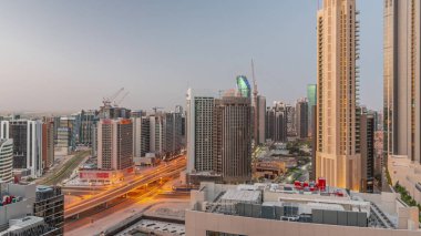 Dubai 'deki Business Bay' deki gökdelenler gece gündüz geçiş zamanları. Güneş doğmadan önce yeni vinçleri olan yeni kulelerin yol kesişme ve inşaat sahası, Birleşik Arap Emirlikleri