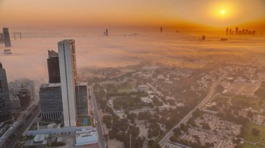 Dubai, BAE 'de gündoğumunda arka planda panoramik panoramik zaman aralığı olan Zabeel bölgesindeki villalar. Evleri ve yolları sabah sisiyle kaplı caddelerde trafik vardı.