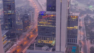 Ofis gökdelenleri. Finans bölgesi havacılığında aydınlanma. Gece gündüz geçiş zamanı. Güneş doğmadan önce yukarıdan otellere ve trafiğe tepeden bakıldığında