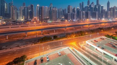 Dubai marinası gece gündüz gökdelenlerin en yüksek bloğu gün doğumundan önce geçiş zamanı. JLT bölgesinden apartman binalarına, otellere ve otoyol yakınlarındaki iş kulelerine hava manzarası.