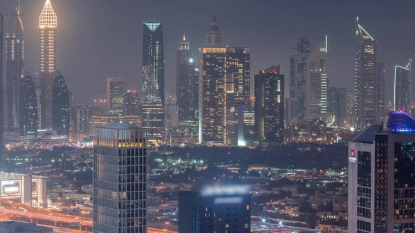 Rows of skyscrapers in financial district of Dubai aerial day to night transition timelapse. Panoramic view to many towers from Business bay district
