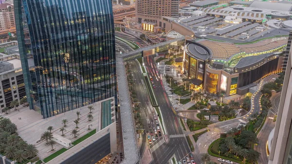Aerial panorama of Downtown Dubai with shopping mall and traffic on a street day to night transition timelapse from above, UAE Modern skyscrapers and hotels