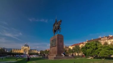 Monument of the Croatian King Tomislav timelapse hyperlapse and art pavilion in colorful park, in Zagreb, capital of Croatia. Blue cloudy sky before sunset. Panoramic view