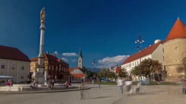 Holy Mary monument on square in front of the Cathedral timelapse hyperlapse and Historic buildings in city center in Zagreb, Croatia. People walking around