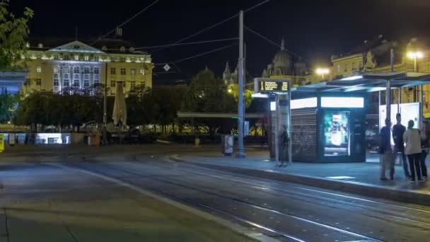 クロアチアの首都ザグレブの新しい近代的なトラムは 鉄道駅の近くで夜のタイムラプス トラムの人々は夕方に停車します クロアチア — ストック動画