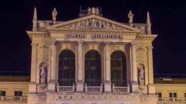 İnsanların önünde Main Railway Station gece timelapse hyperlapse, Hırvat demiryolları ağının ana hub Tomislav meydanında. Yolda trafik. Zagreb, Hırvatistan