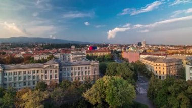 Hırvatistan 'ın Zagreb kentindeki ulusal tiyatro ve müzenin önündeki kavşakta yer alan şehir merkezinin zaman çizelgesinin panoraması gökdelenin tepesinden çekiliyor. Gün batımından önce hava görüntüsü
