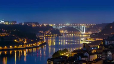 City of Porto and Gaia from evening to night transition by the Douro river aerial timelapse in Portugal, Arrabida Bridge at the far end.