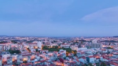 Aerial view on Rooftops of Portos old town on a warm spring evening timelapse day to night transition from above, Porto, Portugal. Lights turning on