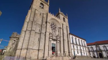 Porto Cathedral or Se Catedral do Porto timelapse hyperlapse front view with blue sky at sunny day. Romanesque and Gothic architecture.