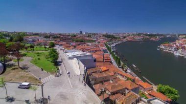 Aerial view over red roofs of the historic city of Porto, Portugal with the park timelapse with blue sky. Waterfront with red roofs