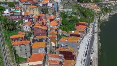 Aerial view of Funicular dos Guindais and red roofs of picturesque houses in historic centre of Porto city timelapse from the Dom Luiz bridge, Portugal