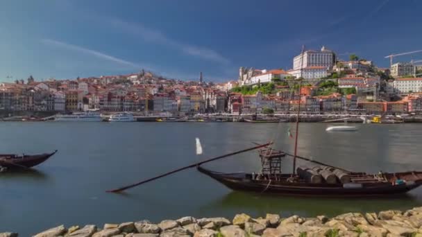 ポルトガルのポルトは 晴れた日にドゥオーロ川の旧市街のスカイラインで ルイス1世橋のあるラベロ船が過経過しています 街のスカイラインを背景に — ストック動画
