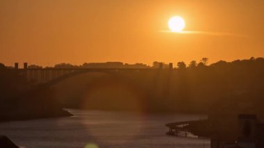 Sunset over old city Porto at river Duoro, with orange sky and the Arrabida bridge, Oporto, Portugal. Aerial view from above at evening