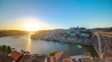 Panorama of old city Porto at river Duoro, with Port transporting boats at sunset timelapse with the Dom Luiz bridge, Oporto, Portugal