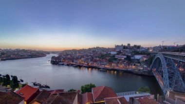 Panorama old city Porto at river Duoro, with Port transporting boats day to night transition timelapse with the Arrabida bridge after sunset, Oporto, Portugal