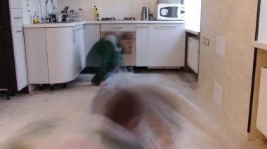 Yeşil üniformalı marangoz işçiler döşeme çalışma saatleri sırasında parke tahtasının önüne substrat kuruyor. Dairede hazırlayıcı iş