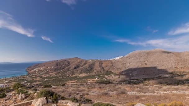 全景显示阿莫罗戈斯岛的空中时间从上方经过 传统的希腊 山丘上的白色房屋和碧绿的大海 环形山 — 图库视频影像
