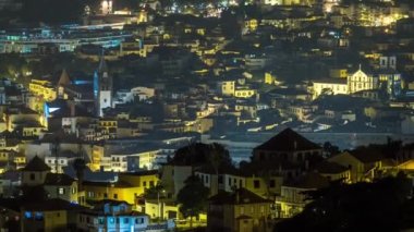 Portekiz 'in Madeira Adası' ndaki Funchal 'ın gece görüntüsü. Şehir merkezindeki bir meydanda ve caddelerde aydınlatılmış biülsiyonlar