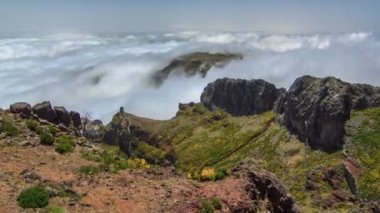 Pico do Arieiro, Madeira, Portekiz 'in yamaçlarından ve taşlarından bulutların üzerindeki hava manzarası. Sisin yukarısına bak