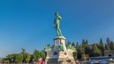 Michelangelo 'nun Floransa' daki Piazzale Michelangelo zaman tünelinde yaptığı David heykelinin bronz kopyası. Yaz günü yeşil ağaçlar ve mavi gökyüzü. Etrafta dolaşan insanlar