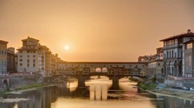 Florence Timelapse, İtalya 'daki Arno Nehri üzerindeki Florence Ponte Vecchio' nun günbatımı manzarası. Floransa mimarisi. Floransa 'nın ana simgelerinden biri.