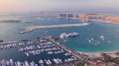 Gün batımında Dubai Marina Panorama 'dan Palm Jumeirah Adası' na hava görüntüsü. Yat ve teknelerle yukarıdan manzara