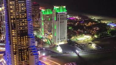 Gökdelenlere gece görüşü ve Dubai Marina 'daki trafik saatleriyle köprü. JBR plajında aydınlık kuleler