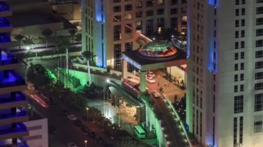 Gökdelenlere gece görüşü ve Dubai Marina 'daki trafik saatleriyle köprü. Yanan kuleler, geçitten geçen arabalar.