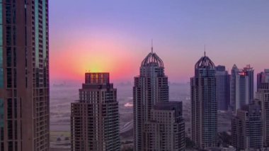 Dubai Marina 'da güneş doğuyor. Kuleleri ve yatı gökdelenlerin çatısından, Dubai' den, UAE hava zaman çizelgesinden. Sabah yukarıdan genel bakış