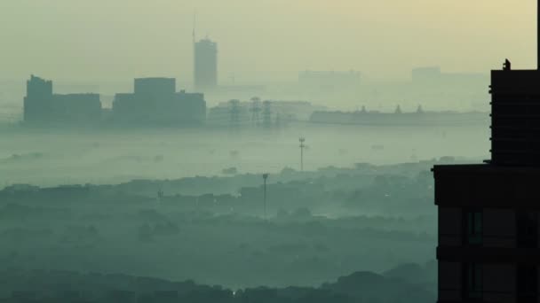 アラブ首長国連邦のドバイマリーナ付近の霧の多い天気の高層ビルからの日の出の間の早朝タイムラプス 電源ラインで上からの眺め — ストック動画