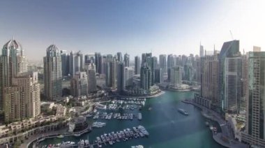 Dubai Marina 'daki modern binalarda sabahtan akşama kadar çok hızlı hareket eden gölgeler var. Havadan çekilmiş panorama, Dubai, BAE. Gökdelenler ve gökdelenler çok sayıda yat ve tekneli.