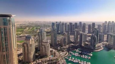 Dubai Marina 'daki modern binaların gölgeleri sabahtan akşama kadar hızla ilerliyor. Dubai, BAE. Gökdelenler ve gökdelenler çok sayıda yat ve tekneli.