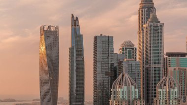 Gün batımında en yüksek yerleşim binaları olan Dubai Marina 'nın gökdelenleri cam bir yüzeyden yansıyor. JLT bölgesinden hava üst görünümü