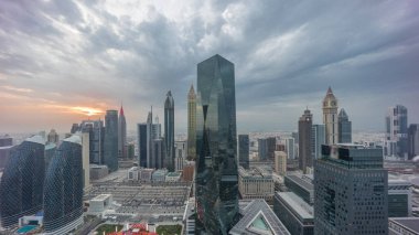 Panorama of futuristic skyscrapers with sunset in financial district business center in Dubai on Sheikh Zayed road . Aerial view from above with colorful cloudy sky