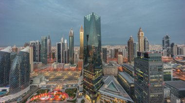 Panorama of futuristic skyscrapers in financial district business center in Dubai on Sheikh Zayed road night. Aerial view from above with illuminated towers with sunrise and long shadows