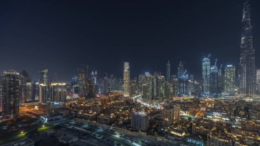 Panorama showing Dubai Downtown and business bay night  with tallest skyscraper and other illuminated towers view from the top in Dubai, United Arab Emirates.