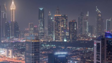 Rows of skyscrapers in financial district of Dubai aerial day to night transition . Panoramic view to many towers from Business bay district