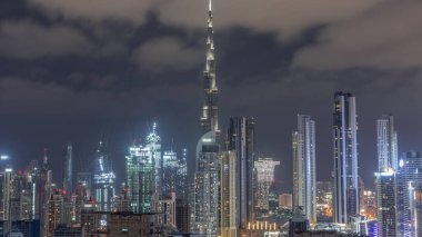 Dubai 'nin panoramik silueti, iş sahasında ve şehir merkezinde tüm gece boyunca şantiyede birçok vinç var. Birçok modern gökdelenin havadan görünüşü. Birleşik Arap Emirlikleri.