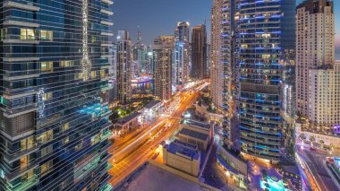 Panoramic view of the Dubai Marina and JBR area aerial day to night transition . Traffic on the road after sunset