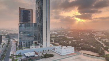 Sunrise in Dubai International Financial district transition . Aerial view of business office towers at morning. Skyscrapers with hotels near downtown