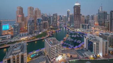 Dubai Marina 'da limana park etmiş birkaç tekne ve yatla ve hava kanallarının etrafındaki gökdelenlerle. JBR bölgesinin kuleleri ve vinçli şantiye