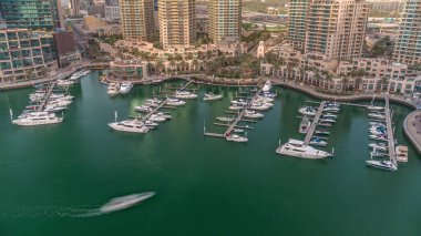 Dubai Marina Havalimanı 'na yanaşmış lüks tekne ve yatlar. Limandaki rıhtım boyunca park etmiş sürat tekneleri ve çeşme.