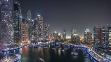 Dubai marinası limandaki en uzun gökdelenler ve yatlar gece panoramiklerinde. Apartman binalarına, otellere ve ofis bloklarına, BAE 'nin modern yerleşim alanlarına bak