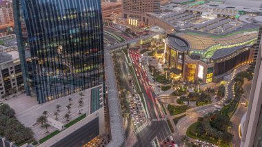 Aerial panorama of Downtown Dubai with shopping mall and traffic on a street day to night transition  from above, UAE Modern skyscrapers and hotels