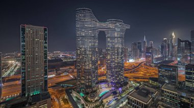 Panorama showing futuristic Dubai Downtown and finansial district skyline aerial night . Many illuminated towers and skyscrapers with traffic on streets
